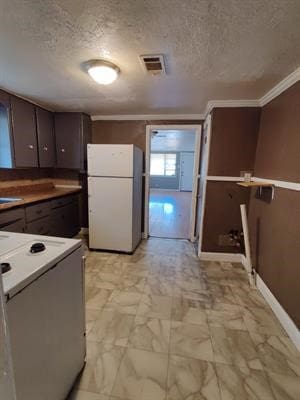 kitchen with white fridge, a textured ceiling, crown molding, and stove