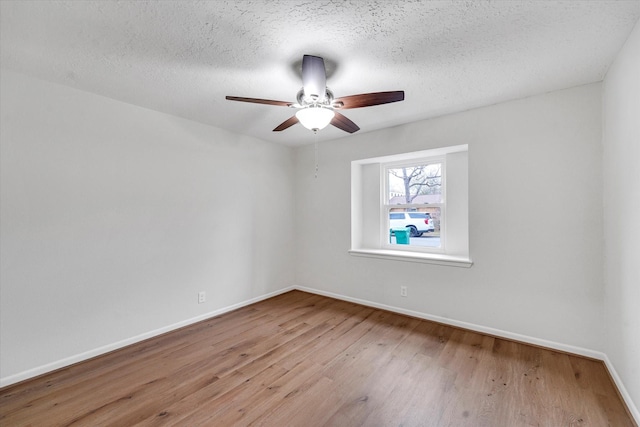 empty room with ceiling fan, a textured ceiling, and light wood-type flooring