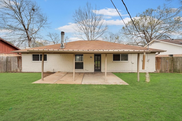 back of property with a yard and a patio area