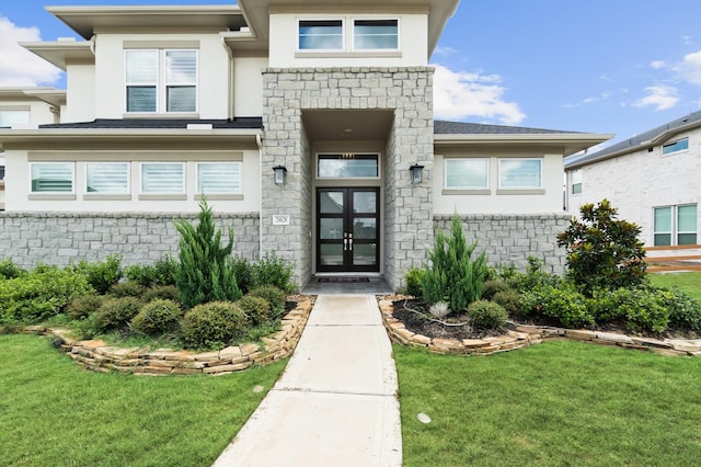 doorway to property featuring french doors and a lawn