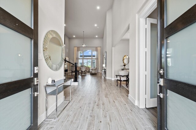 foyer entrance with light wood-type flooring and a high ceiling