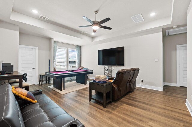 living room featuring billiards, ceiling fan, hardwood / wood-style floors, and a tray ceiling