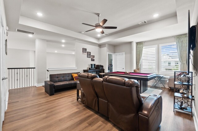 living room featuring ceiling fan, hardwood / wood-style flooring, a raised ceiling, and billiards