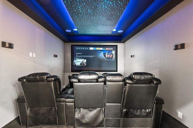 home theater room with a raised ceiling