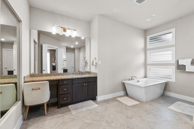 bathroom with vanity, tile patterned floors, and a bath