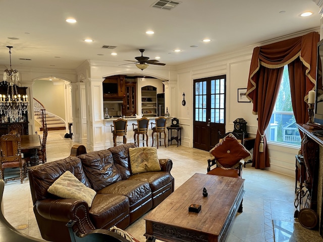 living room featuring decorative columns, ceiling fan with notable chandelier, french doors, and light tile patterned floors