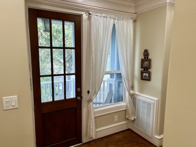 doorway featuring dark hardwood / wood-style floors and crown molding