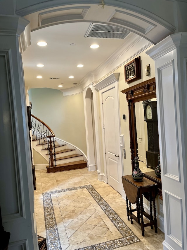 tiled entryway with ornate columns and ornamental molding