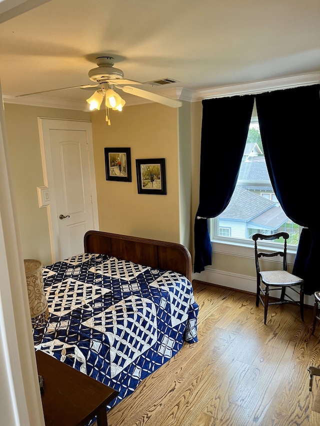 bedroom featuring ornamental molding, ceiling fan, and light hardwood / wood-style floors