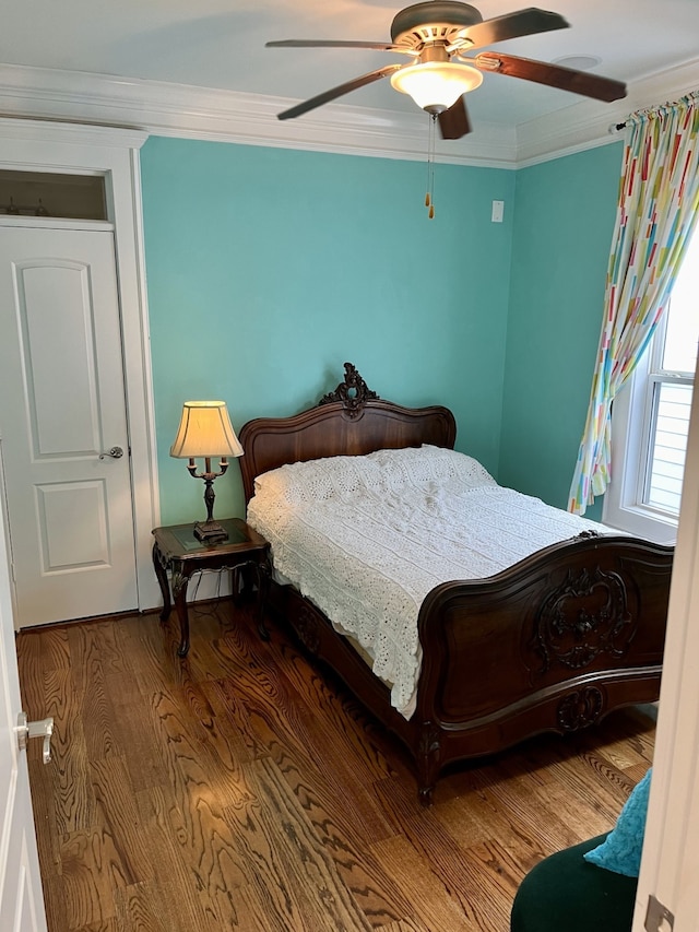 bedroom featuring hardwood / wood-style flooring, crown molding, and ceiling fan