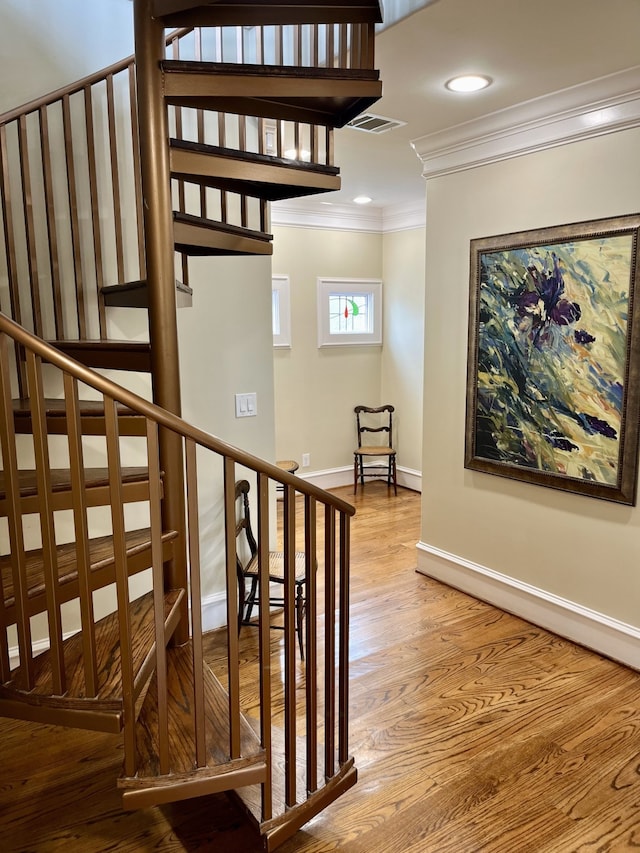 stairway with light hardwood / wood-style floors and crown molding