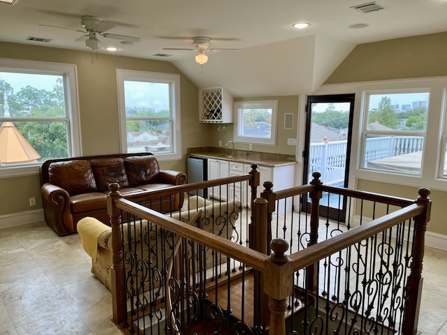 living room with light tile patterned flooring, sink, ceiling fan, and lofted ceiling