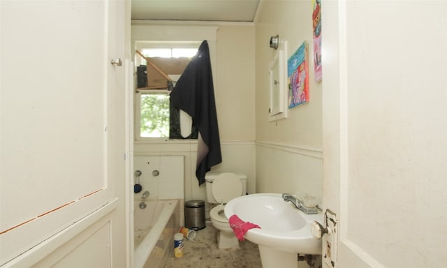 bathroom featuring tile patterned floors, a bathing tub, toilet, and sink