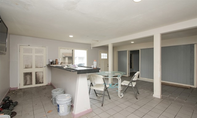 kitchen with light tile patterned flooring, a kitchen bar, and kitchen peninsula