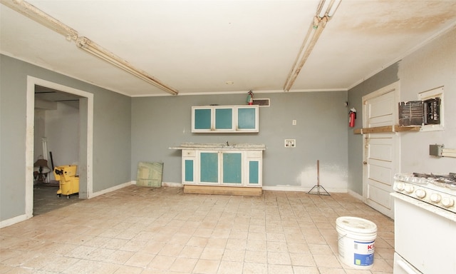 kitchen with light tile patterned flooring, white gas stove, and ornamental molding