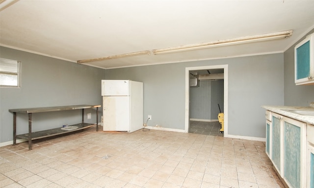 interior space featuring white fridge, crown molding, sink, and light tile patterned floors