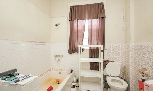 bathroom featuring toilet, a washtub, and tile walls