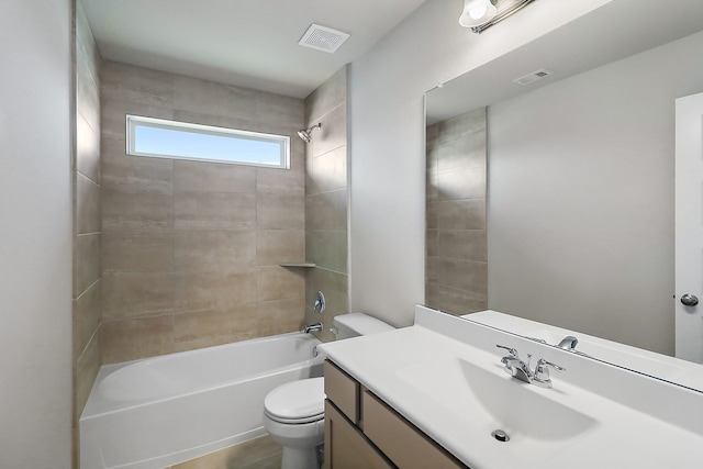 full bathroom featuring vanity, tiled shower / bath, and toilet