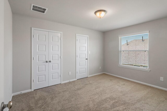 unfurnished bedroom featuring light carpet