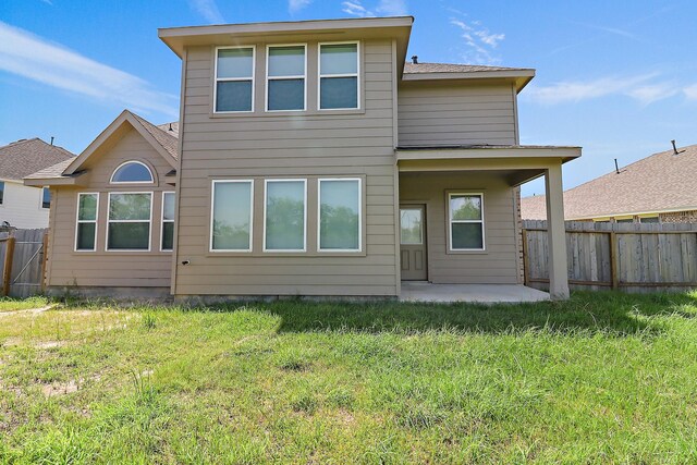 rear view of house with a patio and a lawn