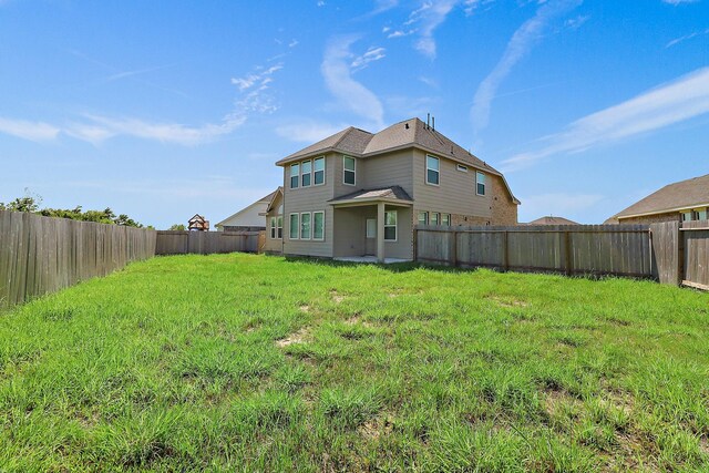 back of house featuring a lawn