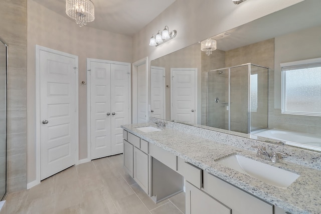 bathroom with dual vanity, tile patterned floors, a notable chandelier, and separate shower and tub