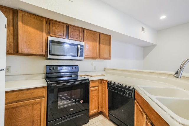 kitchen featuring light tile patterned flooring, black appliances, and sink