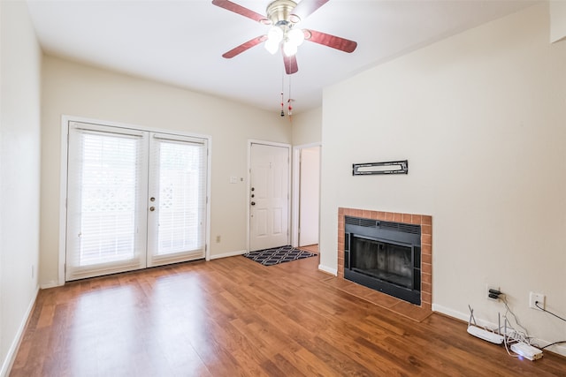 unfurnished living room with ceiling fan, a fireplace, french doors, and hardwood / wood-style flooring