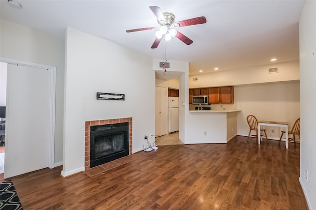 living room featuring a tile fireplace, ceiling fan, and hardwood / wood-style floors