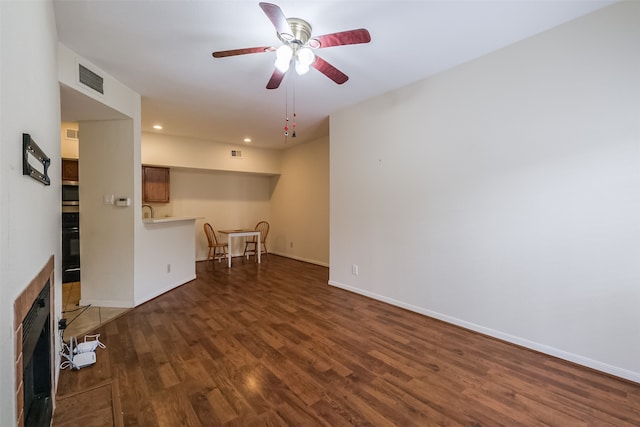 unfurnished living room featuring ceiling fan and dark hardwood / wood-style flooring