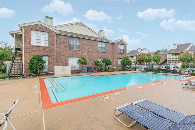 view of swimming pool featuring a patio and central air condition unit