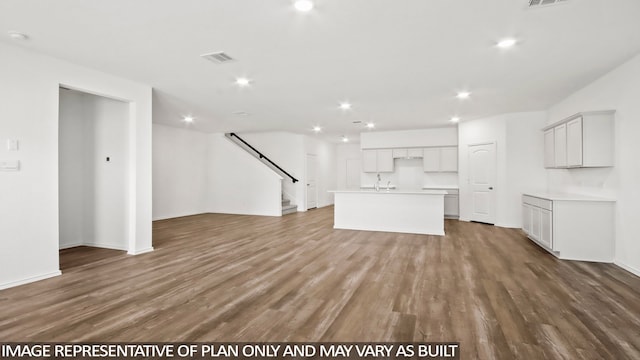 unfurnished living room with wood-type flooring and sink