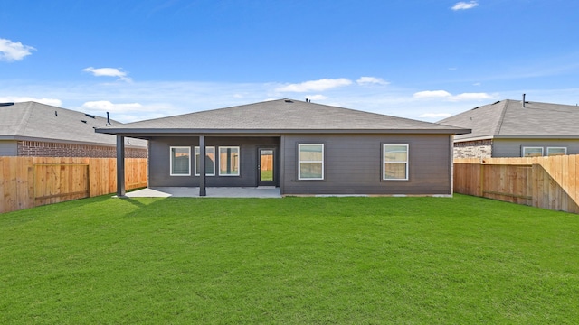 rear view of house featuring a yard and a patio area