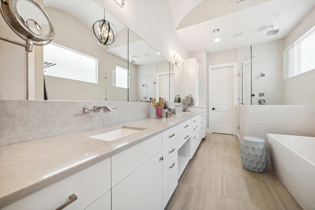 bathroom with vanity, tasteful backsplash, independent shower and bath, and plenty of natural light