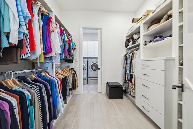 walk in closet featuring washing machine and clothes dryer and light tile patterned floors