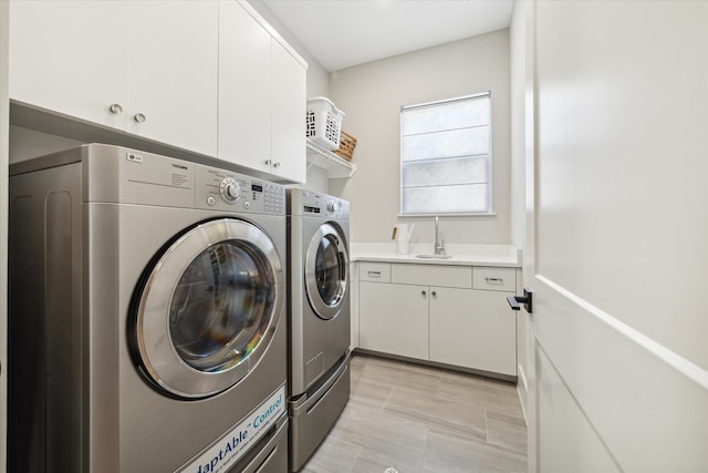 laundry room with cabinets, sink, and washer and clothes dryer