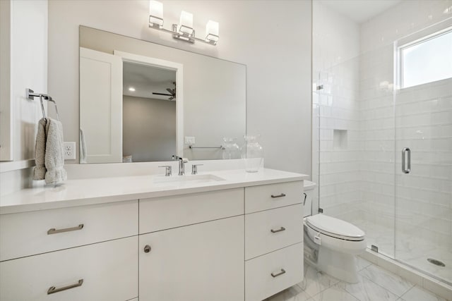 bathroom with vanity, toilet, a shower with door, and ceiling fan