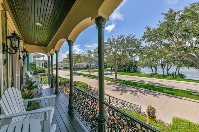 balcony featuring a water view and a porch