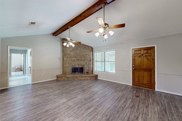 unfurnished living room featuring lofted ceiling with beams, a brick fireplace, hardwood / wood-style floors, and ceiling fan