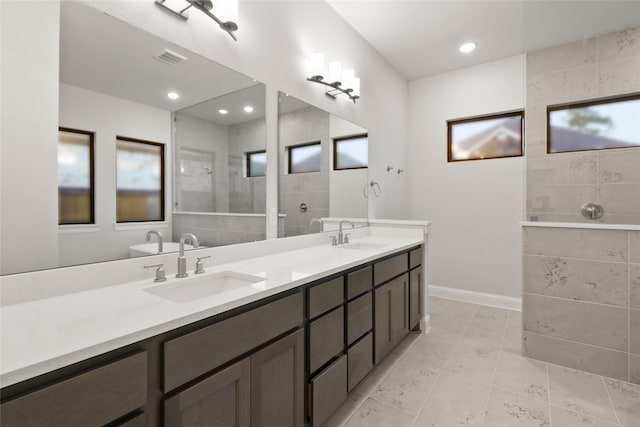 bathroom featuring vanity and tiled shower