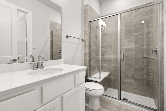 bathroom featuring vanity, toilet, and a shower with shower door