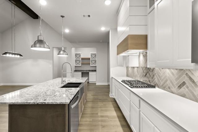 kitchen with a center island with sink, sink, white cabinetry, and hanging light fixtures