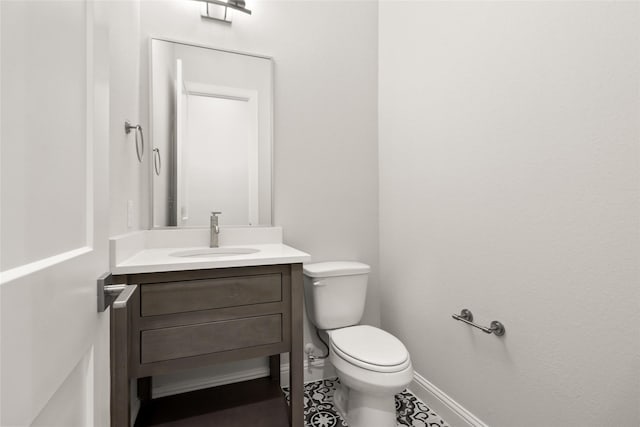 bathroom with tile patterned flooring, vanity, and toilet