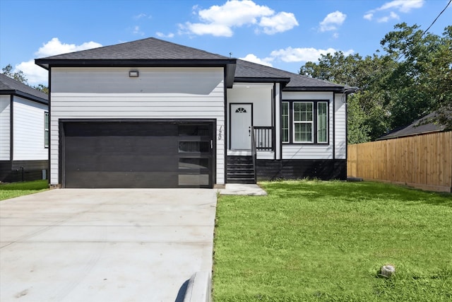 view of front of property featuring a front yard and a garage