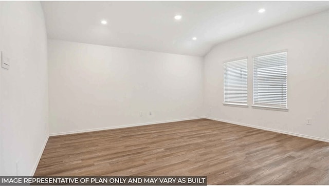 empty room with hardwood / wood-style floors and vaulted ceiling