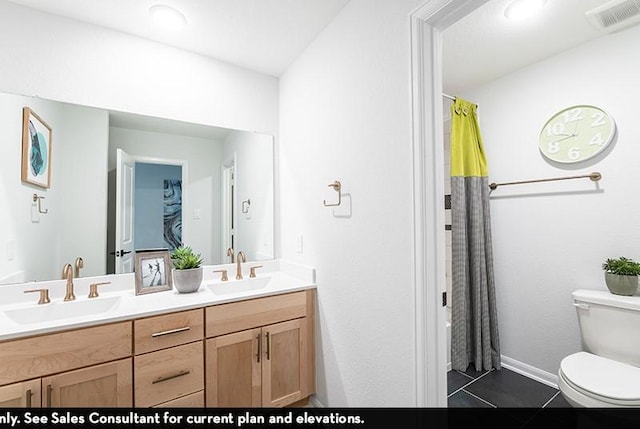 bathroom with tile patterned flooring, vanity, and toilet