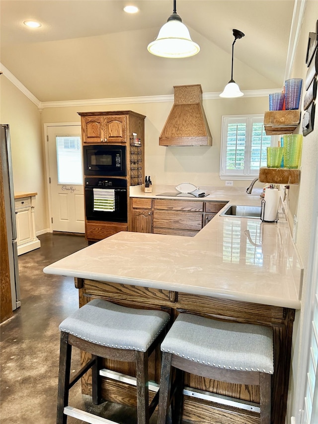 kitchen featuring custom range hood, vaulted ceiling, black appliances, decorative light fixtures, and sink