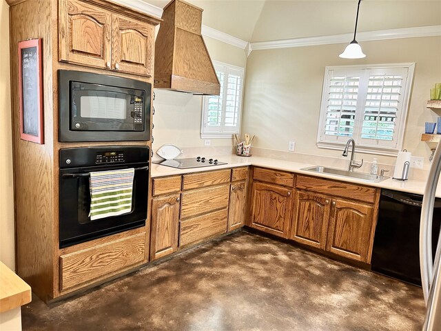 kitchen with lofted ceiling, premium range hood, black appliances, hanging light fixtures, and sink