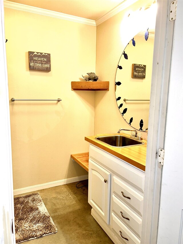 bathroom with concrete flooring, vanity, and ornamental molding