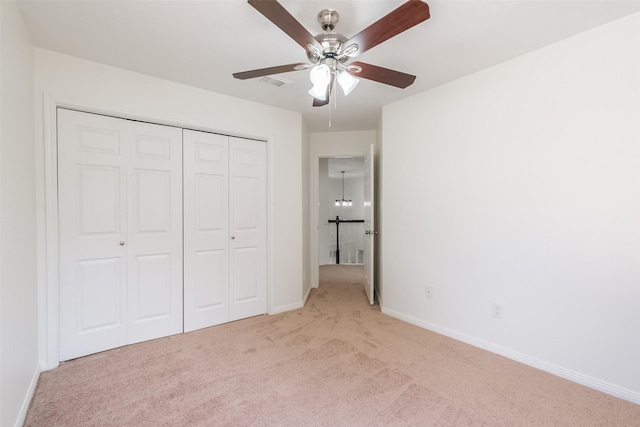 unfurnished bedroom with ceiling fan, light colored carpet, and a closet